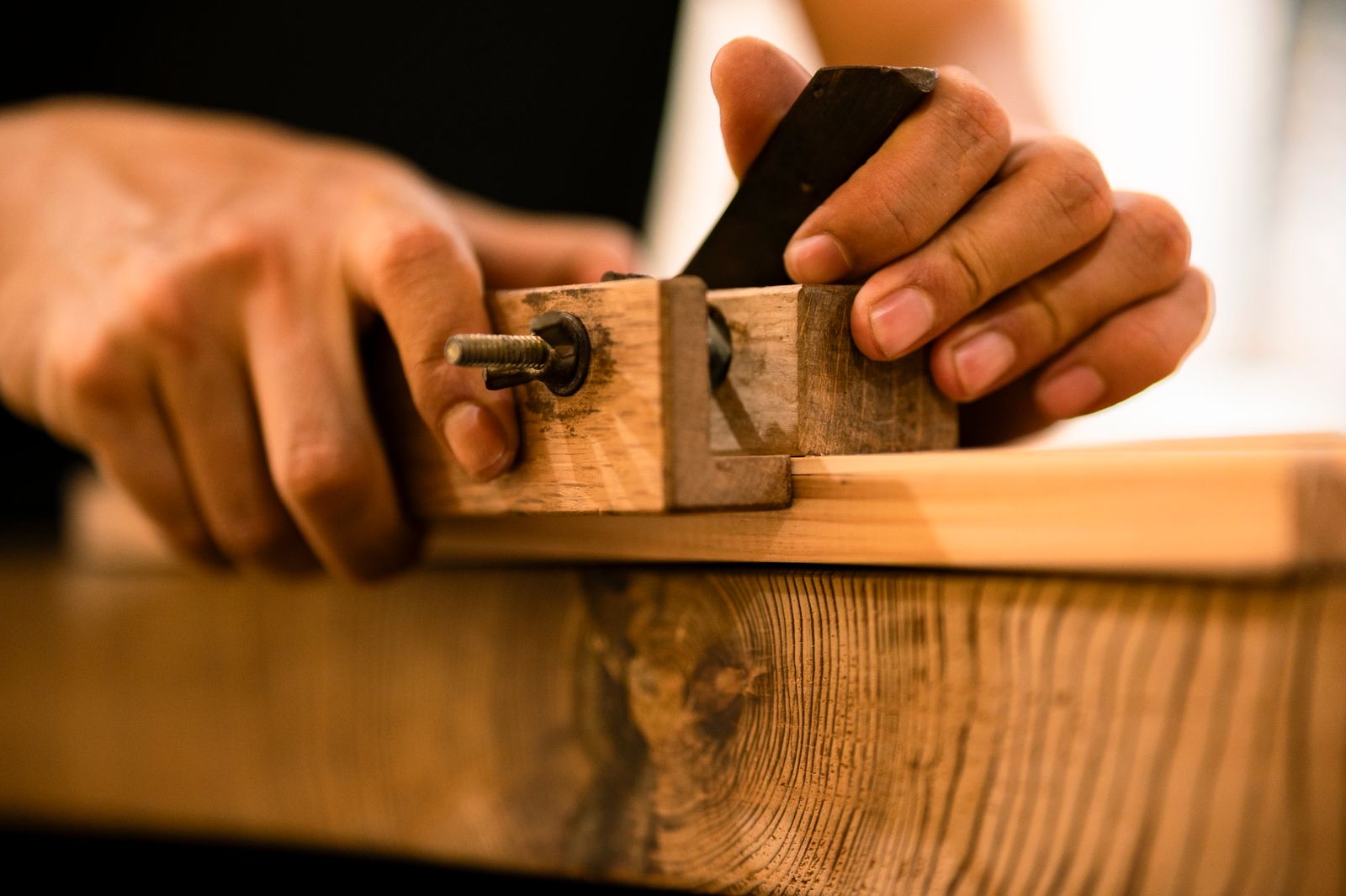 Menuisier rabotant une pièce de bois